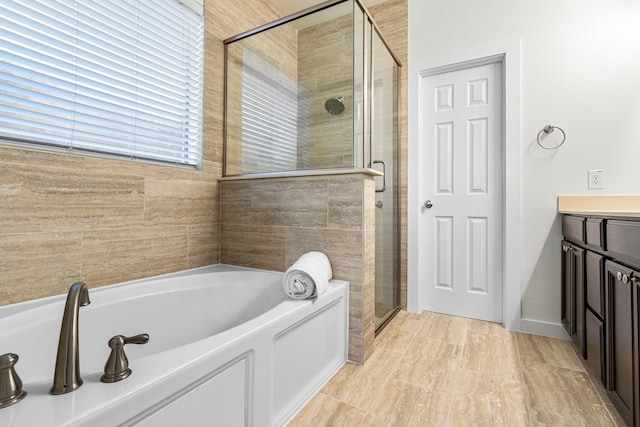 bathroom featuring vanity and independent shower and bath