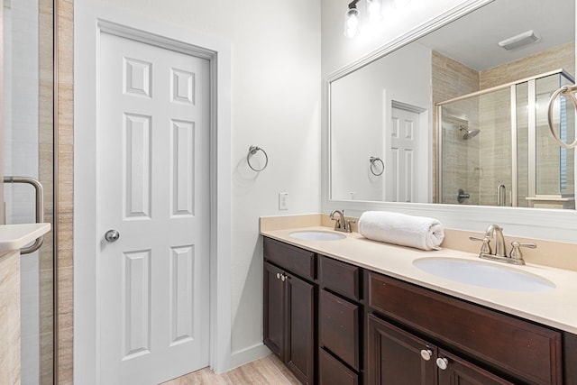 bathroom featuring hardwood / wood-style floors, vanity, and an enclosed shower