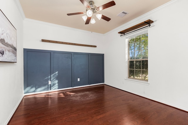 empty room with ceiling fan, dark hardwood / wood-style flooring, and ornamental molding