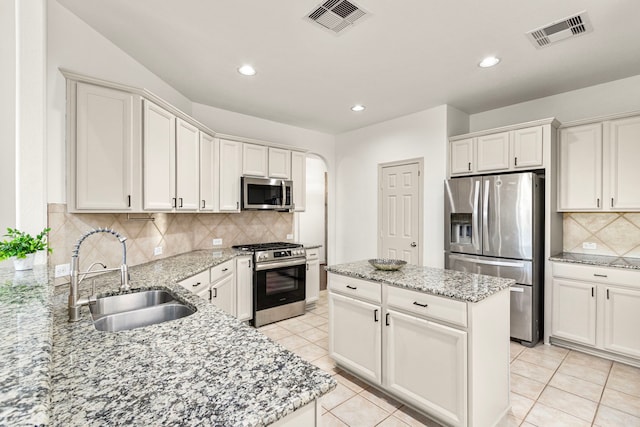 kitchen with decorative backsplash, white cabinetry, sink, and appliances with stainless steel finishes