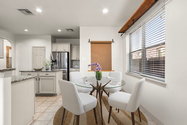 dining room with light tile patterned floors and a barn door