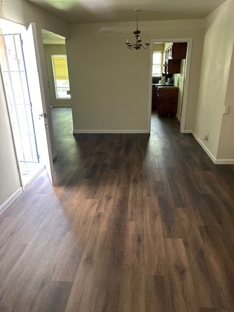 unfurnished dining area with dark hardwood / wood-style floors and an inviting chandelier