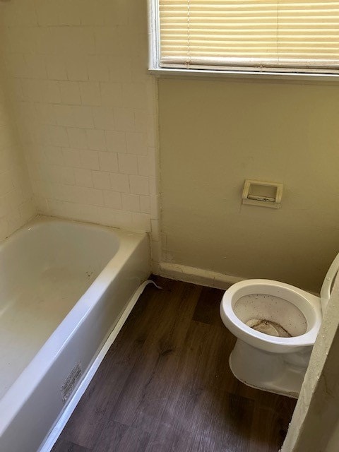 bathroom featuring a washtub, wood-type flooring, and toilet