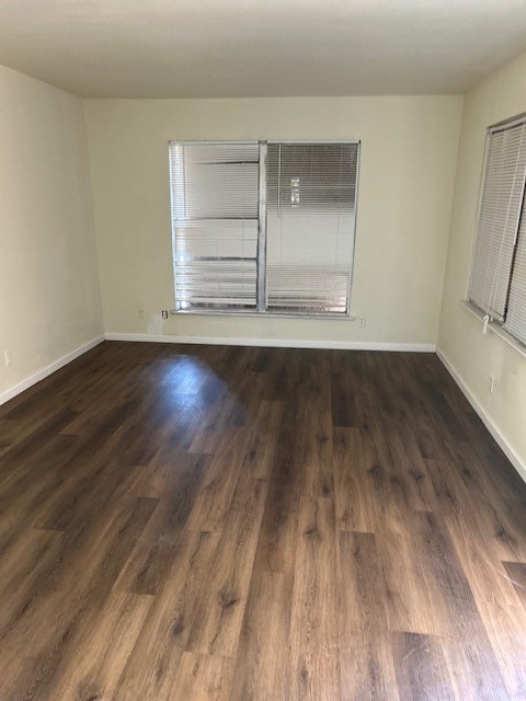 spare room with dark wood-type flooring