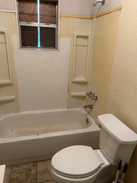 bathroom with tile patterned flooring, toilet, and shower / washtub combination