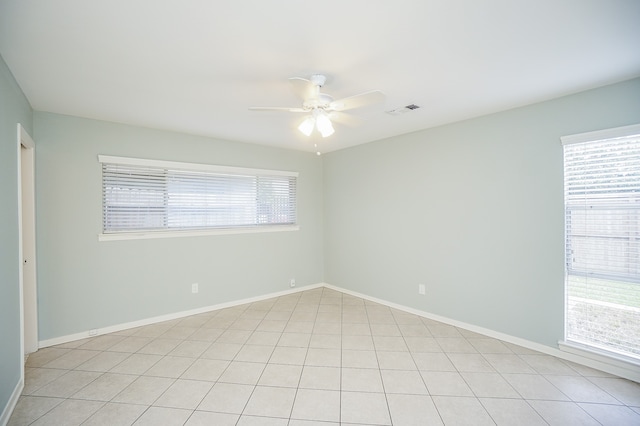 empty room featuring light tile patterned flooring, plenty of natural light, and ceiling fan