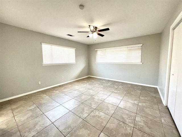 empty room with tile patterned floors and ceiling fan