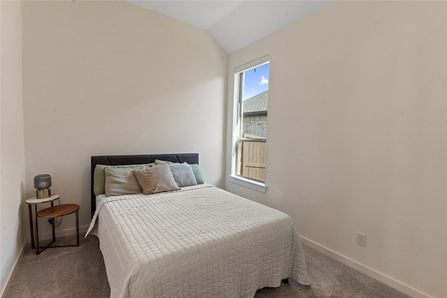 carpeted bedroom with lofted ceiling