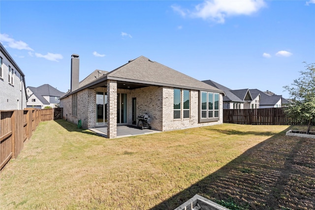 back of property with a lawn and a patio area