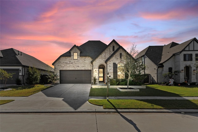 french country inspired facade featuring a yard and a garage