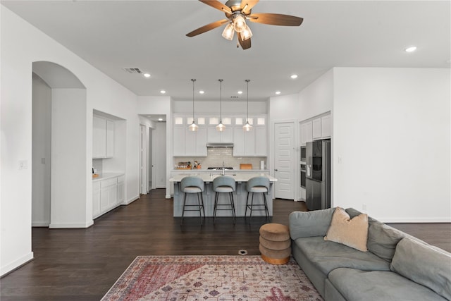 living room with ceiling fan and dark hardwood / wood-style floors