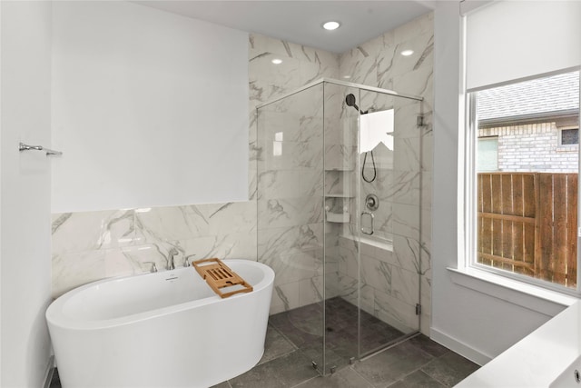 bathroom featuring tile walls and shower with separate bathtub