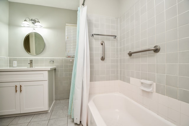 bathroom with tile patterned floors, shower / bath combination with curtain, tile walls, and vanity