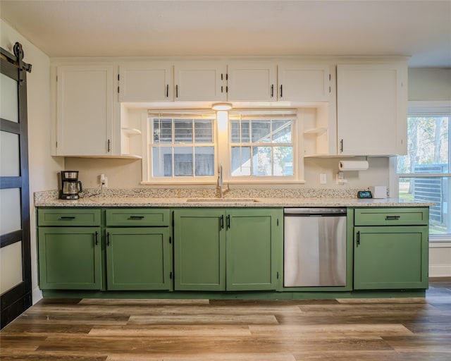 kitchen with sink, white cabinetry, light hardwood / wood-style flooring, stainless steel dishwasher, and a barn door