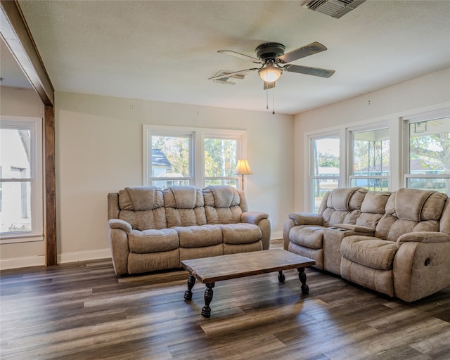 living room with a textured ceiling, ceiling fan, and dark hardwood / wood-style flooring