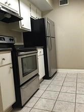 kitchen with electric stove, white cabinets, extractor fan, and light tile patterned floors