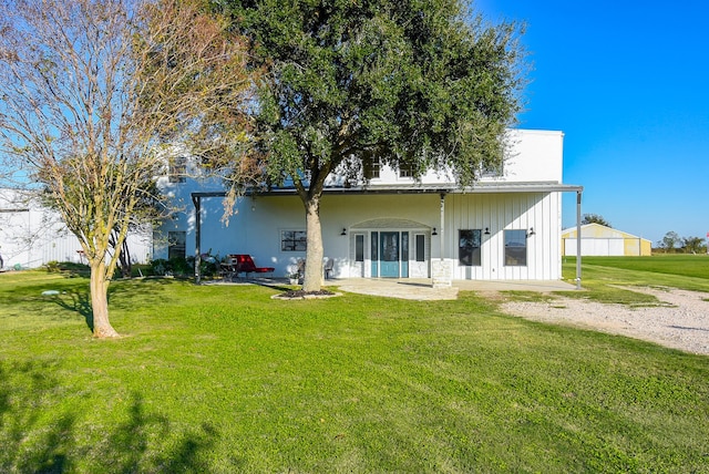 rear view of property featuring a lawn