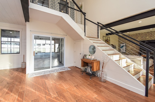 stairway featuring beamed ceiling and hardwood / wood-style flooring