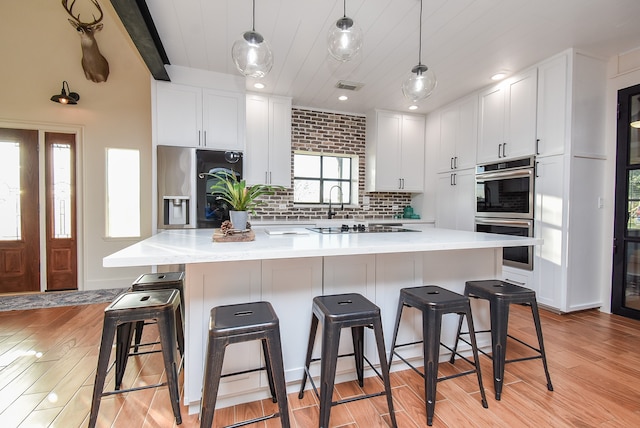 kitchen with stainless steel appliances, a kitchen island, and white cabinetry