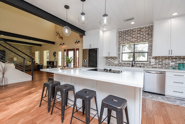 kitchen featuring white cabinets, sink, hanging light fixtures, and black appliances