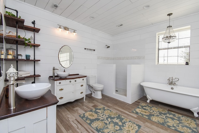 full bathroom featuring vanity, wood-type flooring, an inviting chandelier, independent shower and bath, and toilet