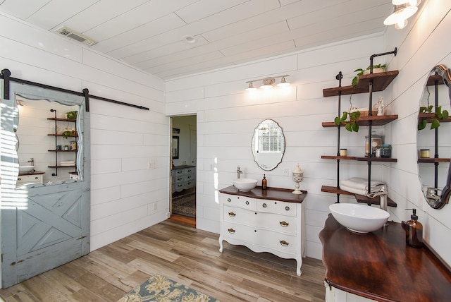 bathroom with wooden walls, vanity, and hardwood / wood-style flooring