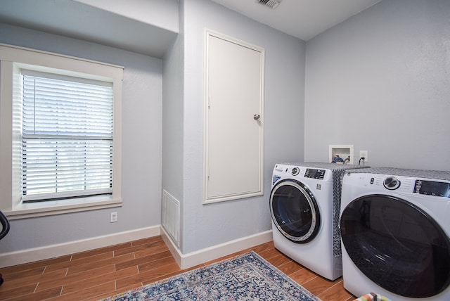 clothes washing area with hardwood / wood-style floors and independent washer and dryer