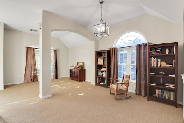 living area featuring a notable chandelier, light colored carpet, and vaulted ceiling