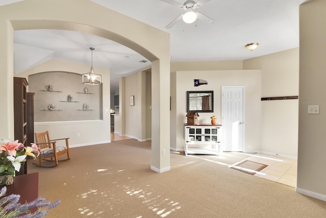 interior space with carpet flooring, built in shelves, and ceiling fan