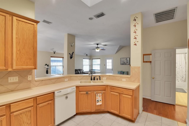 8226 Point Pendleton Dr, Tomball, TX 77375 - kitchen with white dishwasher, a sink, backsplash, a peninsula, and a ceiling fan