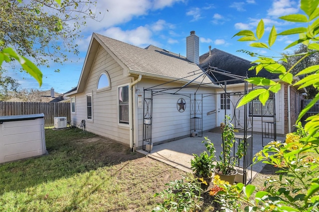 8226 Point Pendleton Dr, Tomball, TX 77375 - back of property featuring a chimney, a patio, and roof with shingles