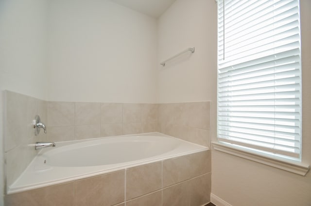 bathroom with a relaxing tiled tub