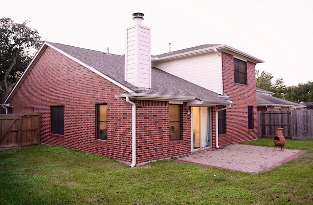 back of house with a lawn and a patio area