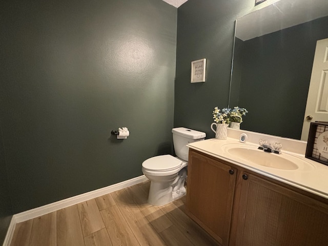 bathroom with toilet, vanity, and hardwood / wood-style flooring