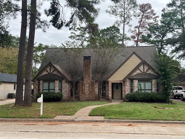 view of front of property with central air condition unit and a front yard