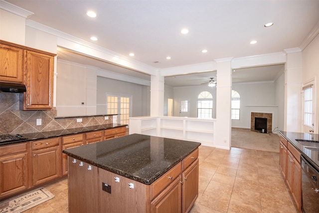 kitchen featuring tasteful backsplash, dark stone counters, stainless steel appliances, ceiling fan, and a kitchen island