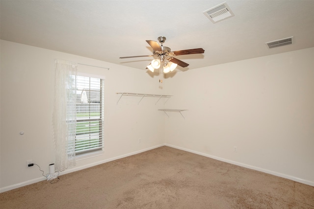 carpeted empty room featuring ceiling fan