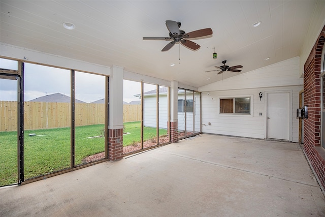 unfurnished sunroom featuring ceiling fan and vaulted ceiling