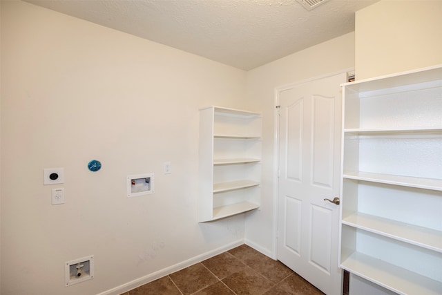 washroom featuring hookup for an electric dryer, dark tile patterned floors, a textured ceiling, and washer hookup