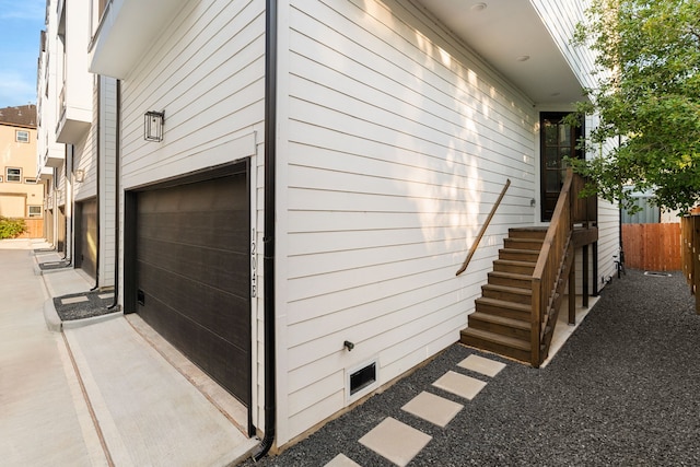 view of home's exterior with a garage and fence