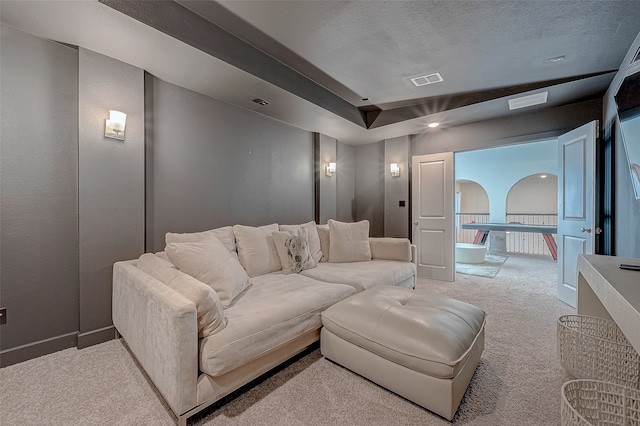 carpeted cinema room with a textured ceiling