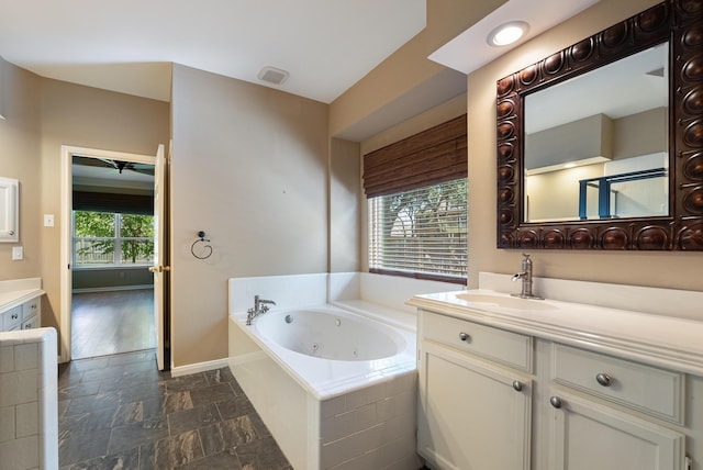 bathroom featuring vanity and tiled bath