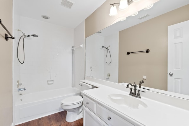 full bathroom featuring hardwood / wood-style floors, vanity, tiled shower / bath combo, and toilet