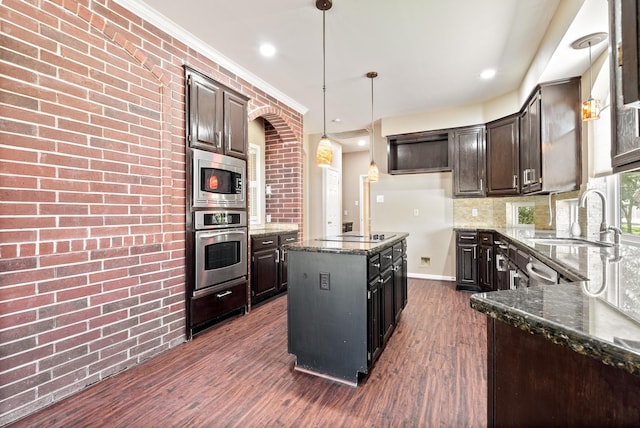 kitchen featuring dark stone countertops, dark brown cabinets, and appliances with stainless steel finishes