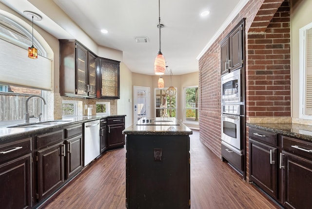 kitchen featuring sink, hanging light fixtures, stainless steel appliances, dark hardwood / wood-style floors, and a kitchen island