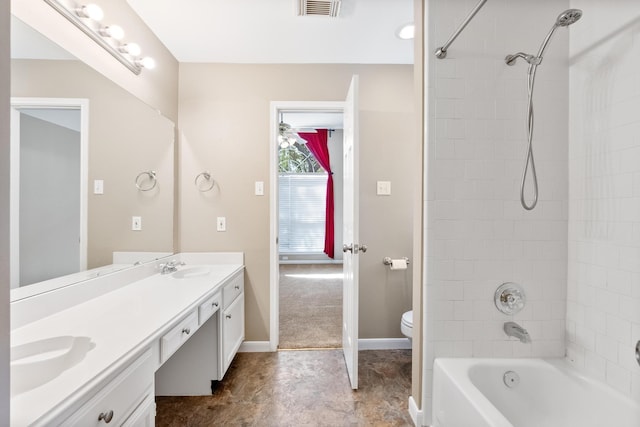 full bathroom featuring vanity, ceiling fan, toilet, and tiled shower / bath