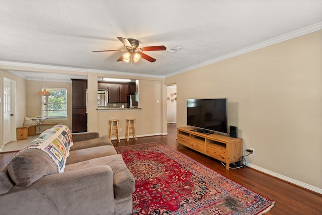 living room featuring a textured ceiling, ceiling fan, crown molding, and dark wood-type flooring