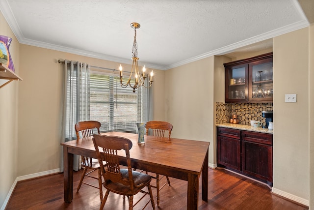 dining room with a textured ceiling, dark hardwood / wood-style floors, ornamental molding, and a notable chandelier