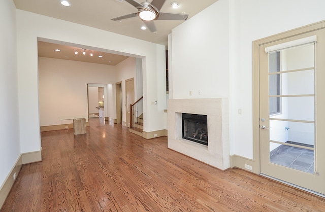 unfurnished living room with ceiling fan and wood-type flooring