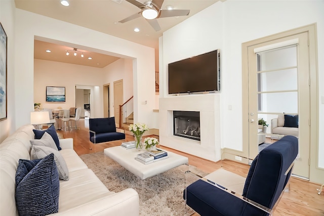 living room featuring ceiling fan and light hardwood / wood-style floors